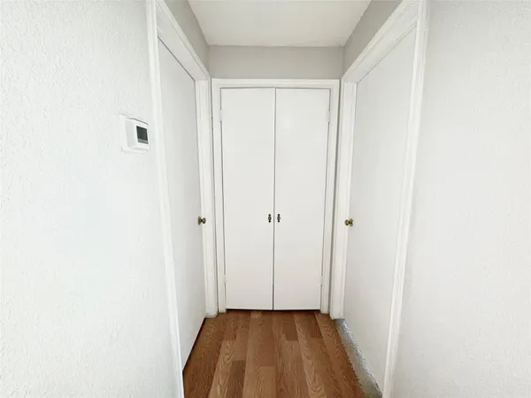 a view of a room with wooden floor and a small space