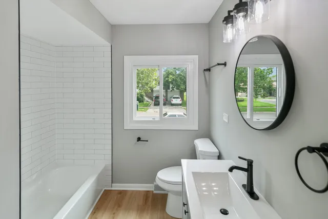 a bathroom with a toilet a sink and a window