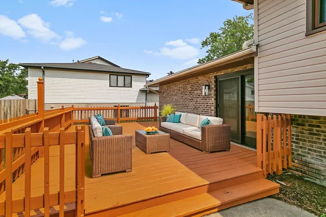 a view of a house with wooden deck and furniture