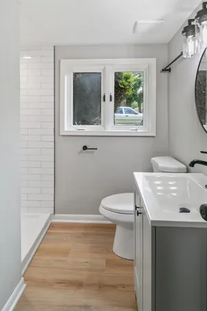 a bathroom with a sink a toilet and a mirror