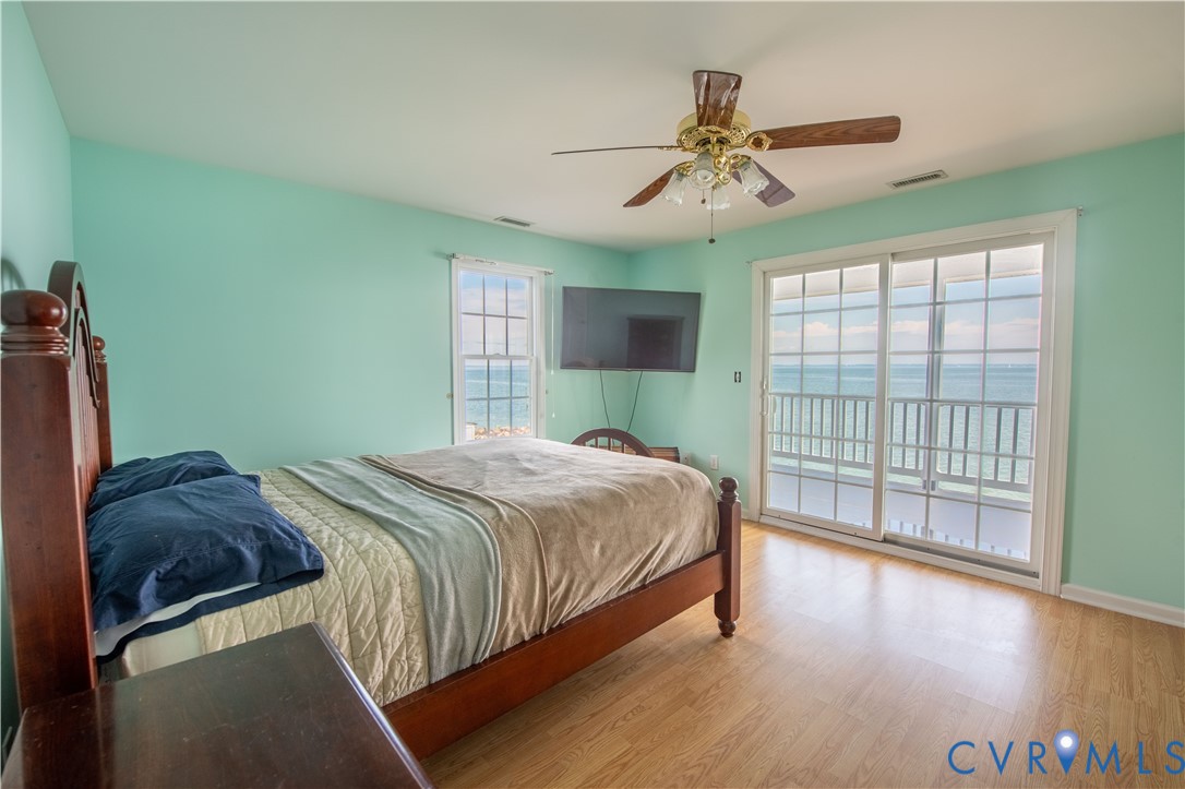 154 Riverside Drive Deltaville, VA 23043 - Photo 24 of 38 a bedroom with a large bed and a chandelier