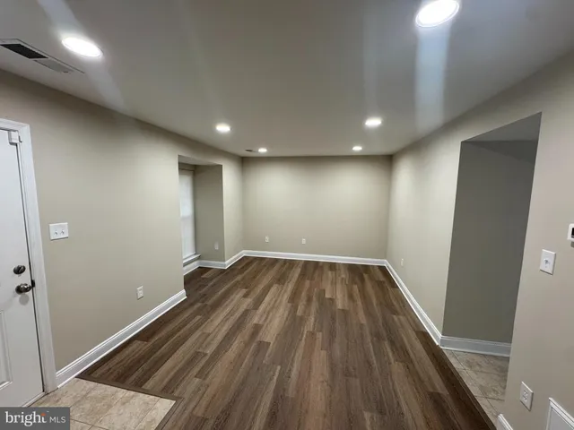 a view of an empty room with wooden floor