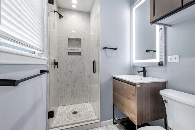 a bathroom with a sink a toilet and shower