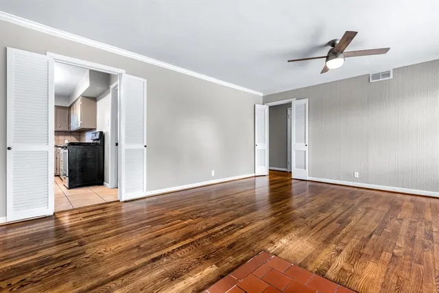 a view of an empty room with wooden floor