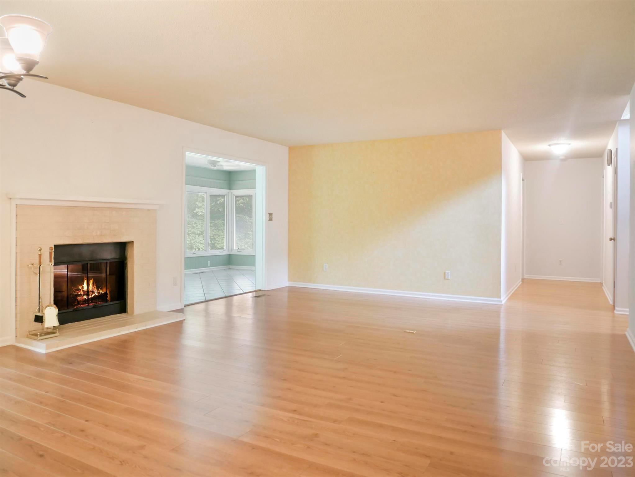 154 Fairlane Road, Unit 2A Columbus, NC 28722 - Photo 5 of 19 a view of an empty room with wooden floor fireplace and a window