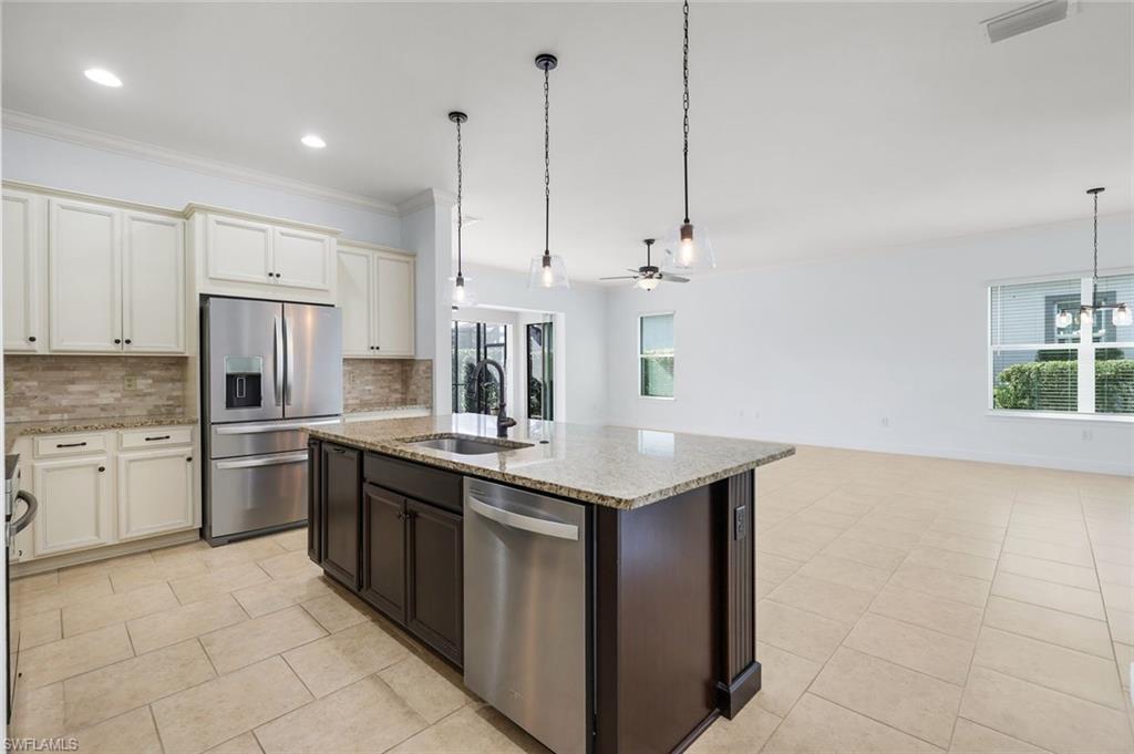 a kitchen with stainless steel appliances granite countertop a sink a stove and a refrigerator