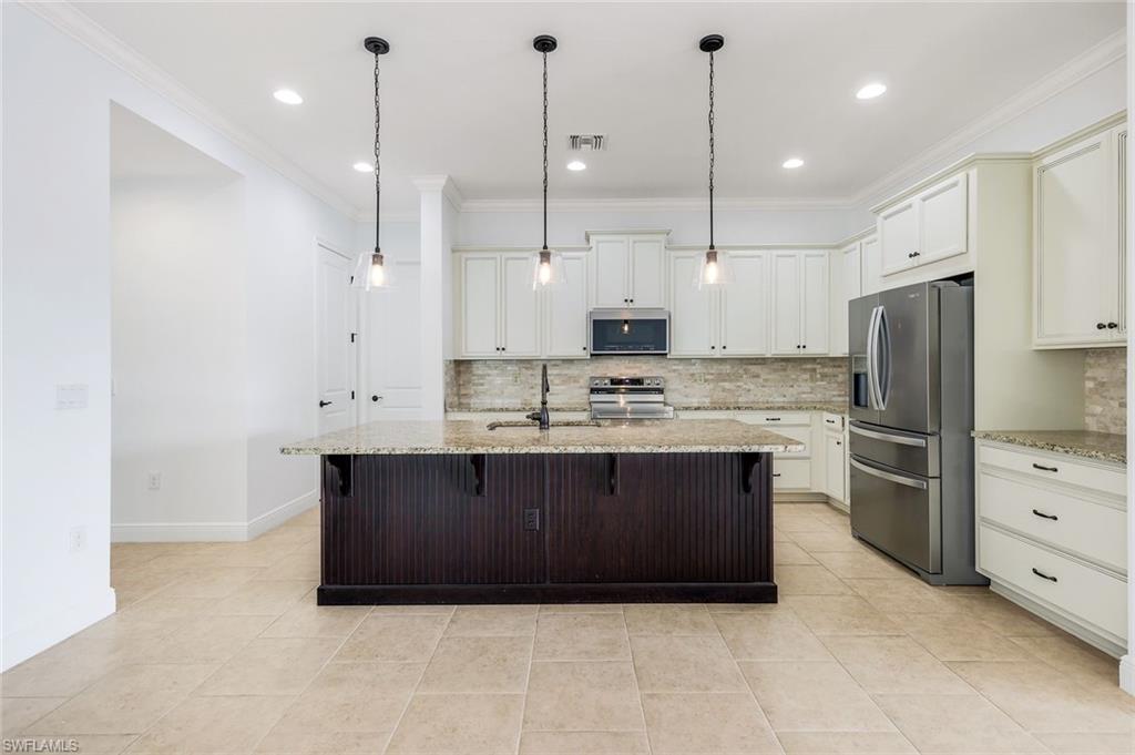 3529 Pilot Circle Naples, FL 34120 - Photo 17 of 47 a large kitchen with stainless steel appliances a refrigerator a sink and a stove