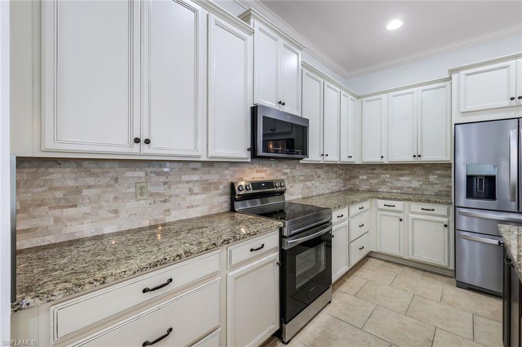 3529 Pilot Circle Naples, FL 34120 - Photo 19 of 47 a kitchen with granite countertop white cabinets and stainless steel appliances