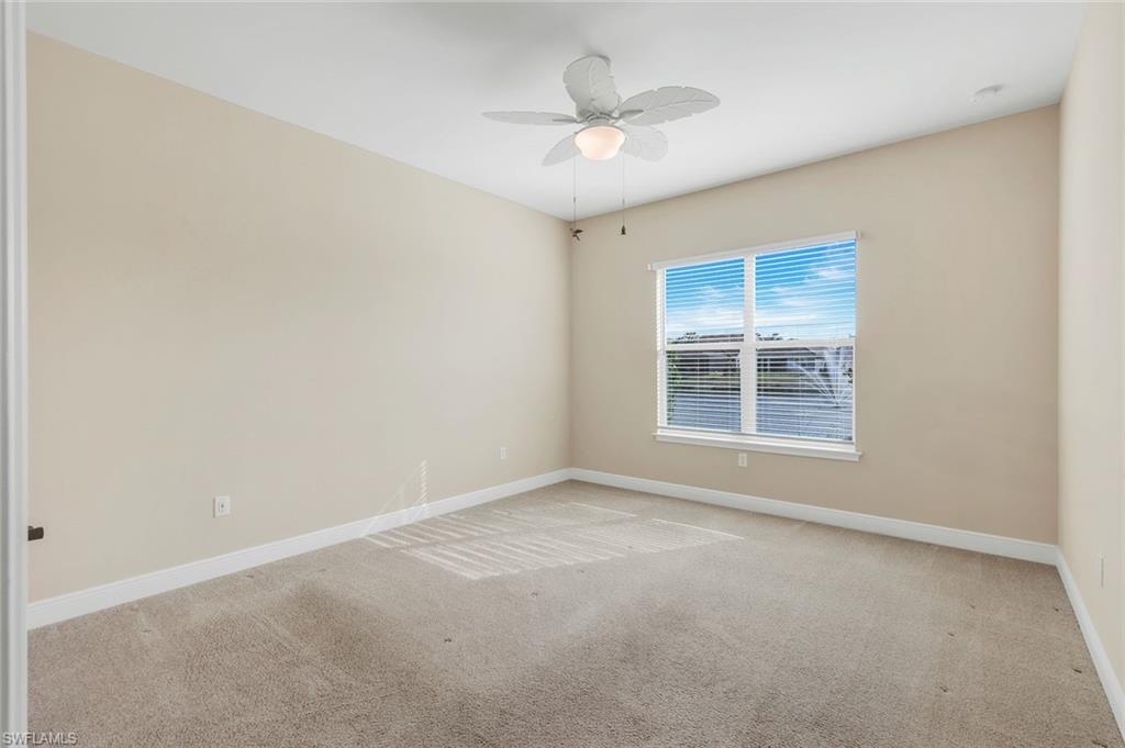 3529 Pilot Circle Naples, FL 34120 - Photo 21 of 47 an empty room with a chandelier fan and windows
