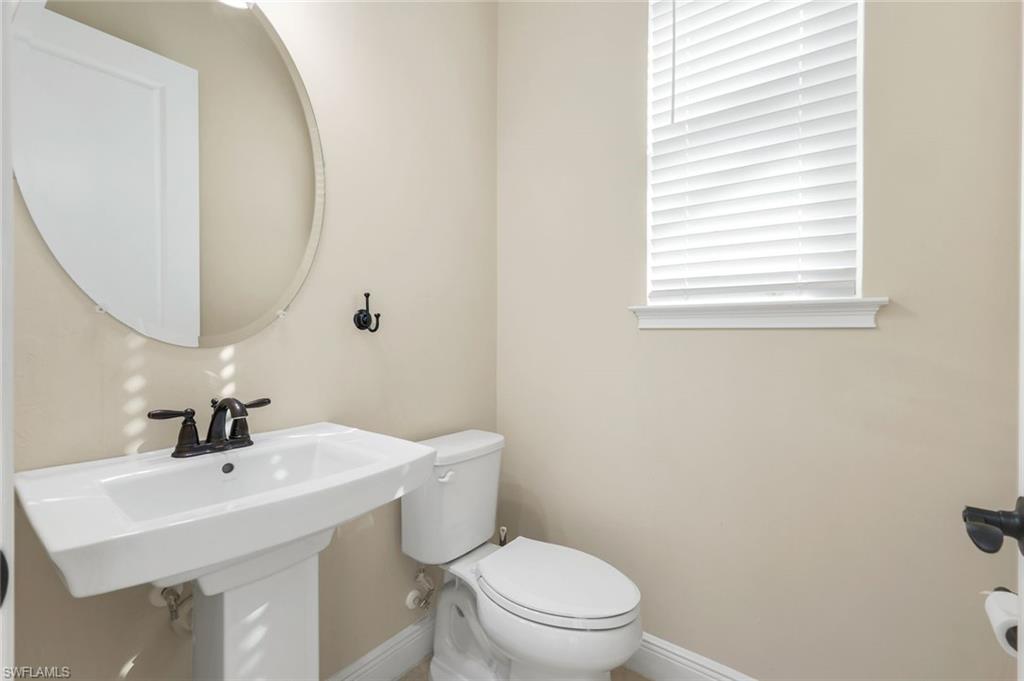 3529 Pilot Circle Naples, FL 34120 - Photo 27 of 47 a bathroom with a toilet a sink a mirror and a window