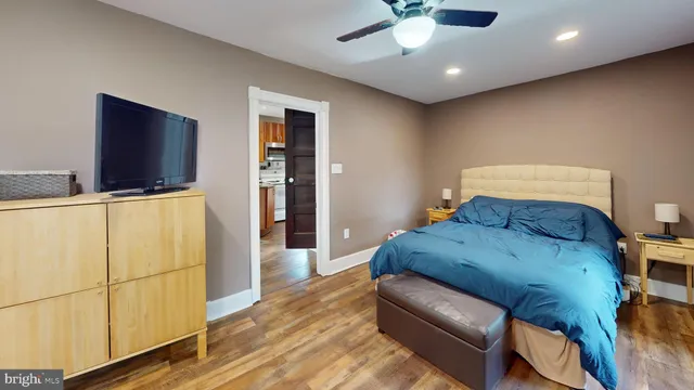 a spacious bedroom with a bed and a flat screen tv