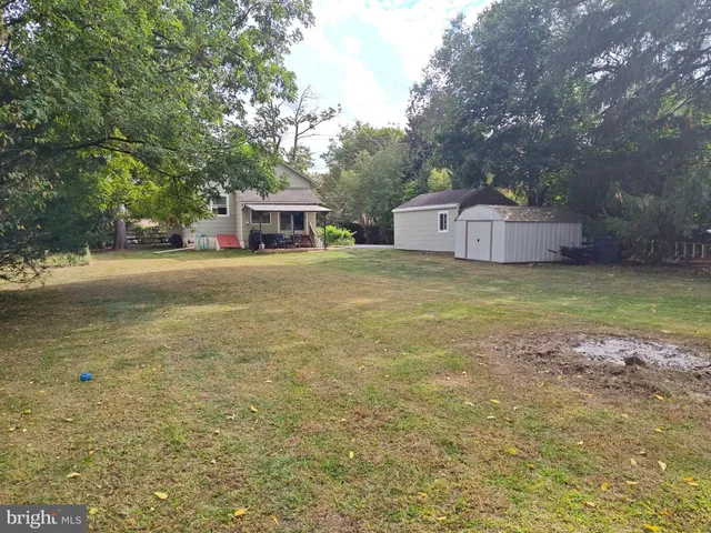 a front view of a house with a garden and trees