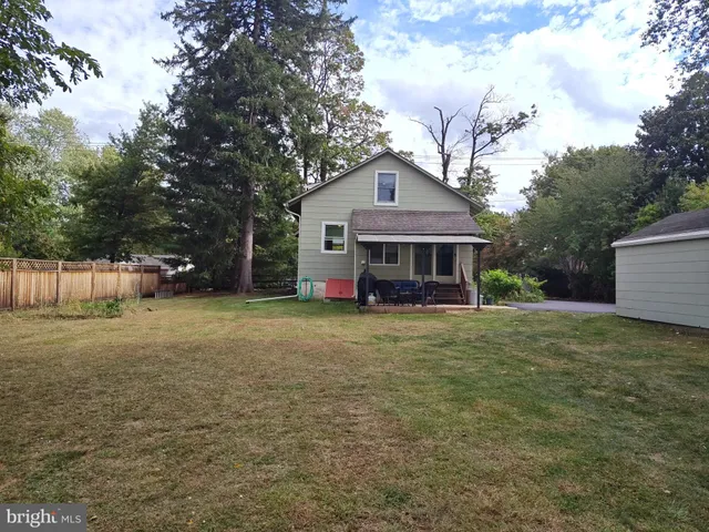 a front view of a house with a garden and trees