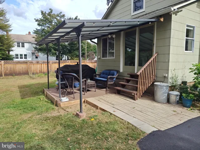 a view of a chair and tables in the patio in front of a house