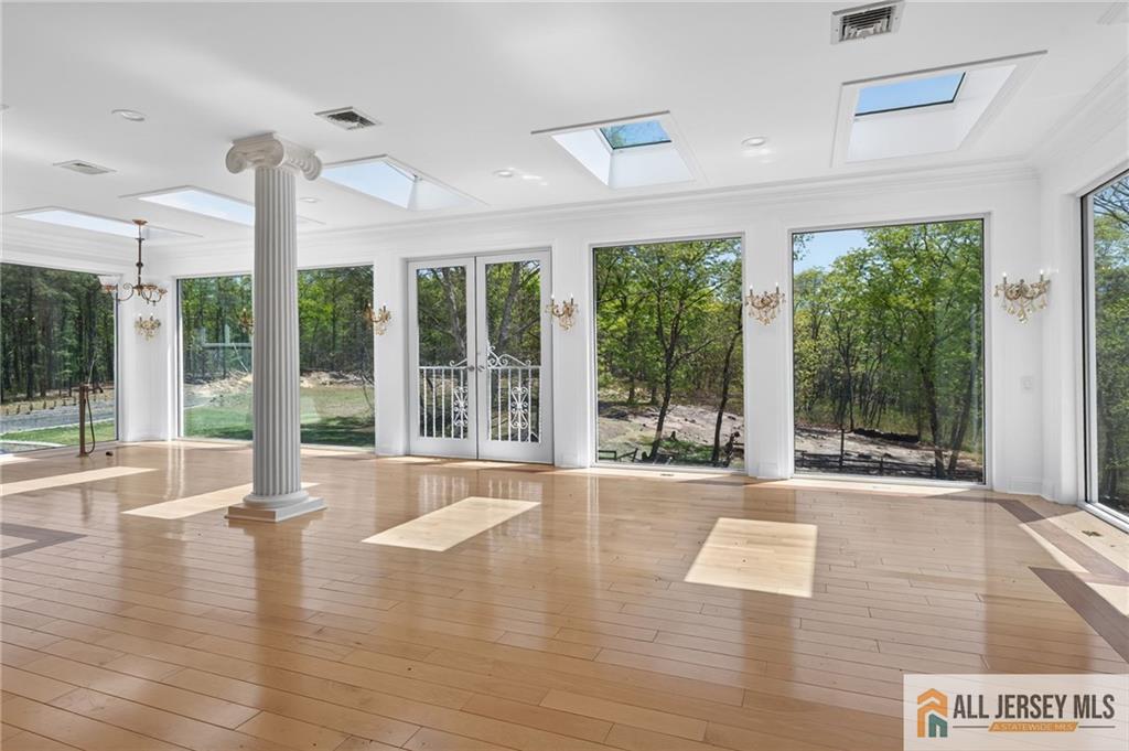 381 Monmouth Road Freehold, NJ 07728 - Photo 22 of 63 a view of an empty room with wooden floor and a large window