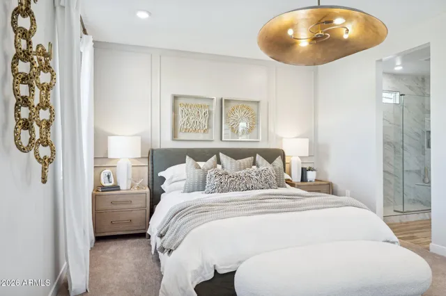 a bedroom with a bed and a chandelier