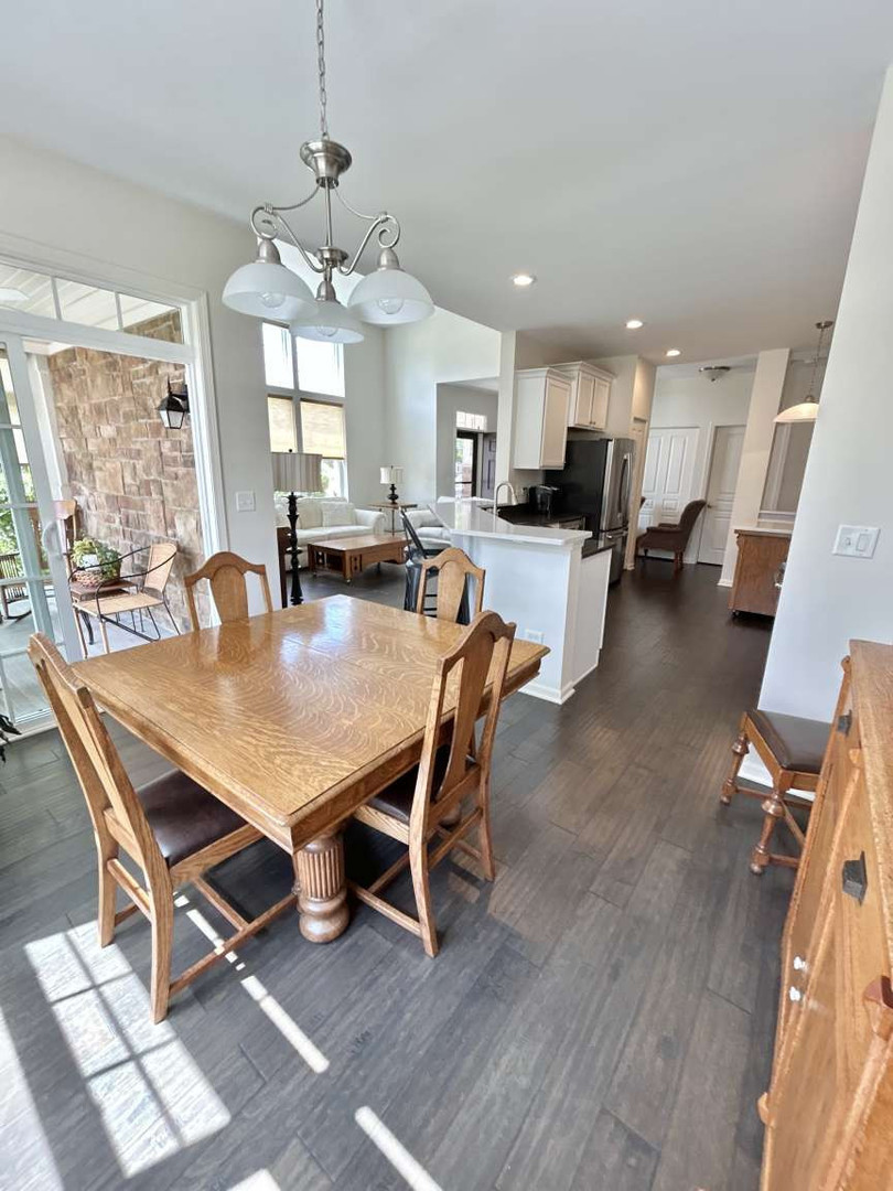 2603 Avondale Circle Naperville, IL 60564 - Photo 16 of 22 a dining room with wooden floor a chandelier a wooden table and chairs