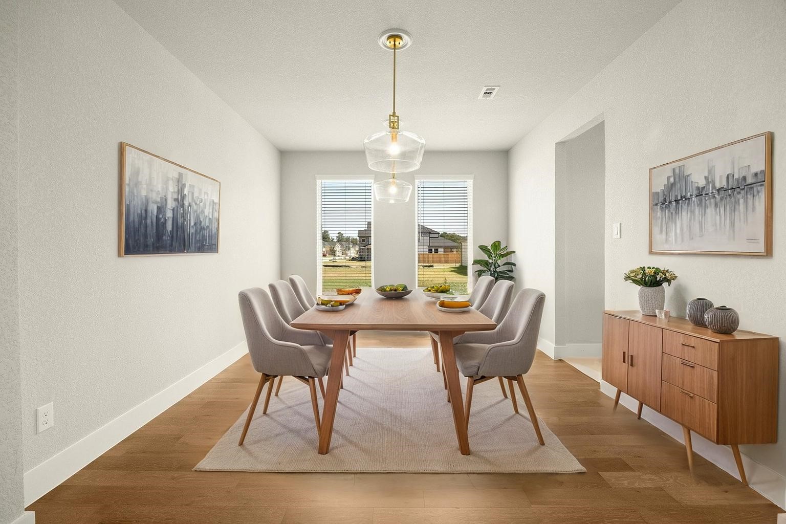 VIRTUALLY STAGED -Bright and inviting dining room featuring a modern wooden table, elegant gray chairs, and large windows that fill the space with natural light.