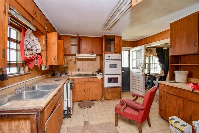 a kitchen that has a sink and chairs