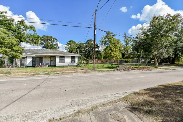 a view of a house with a yard and potted plants