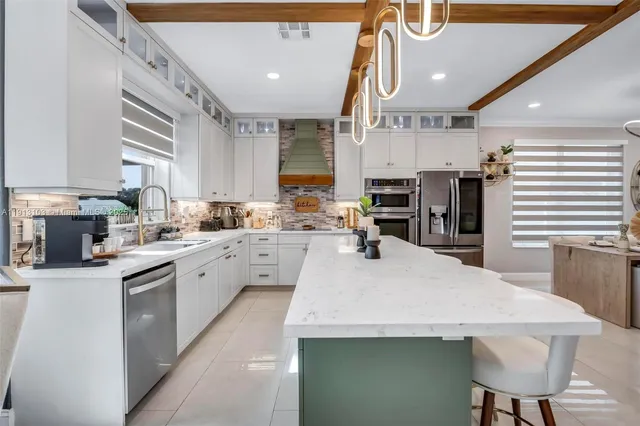 a kitchen with stainless steel appliances a stove refrigerator sink and cabinets