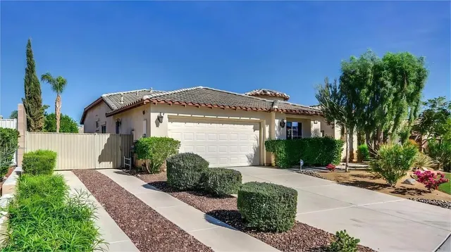 a front view of a house with a yard and potted plants