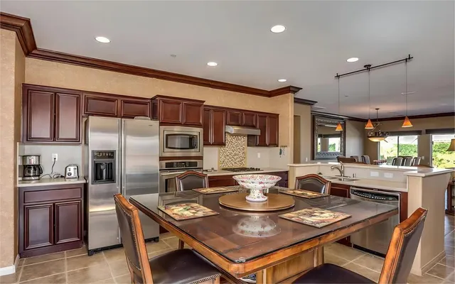 a dining room with stainless steel appliances kitchen island granite countertop a dining table and chairs