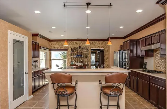 a living room with stainless steel appliances furniture a rug and a large window