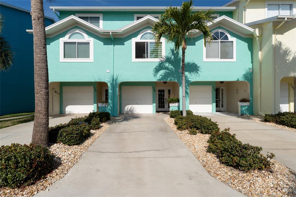 128 Marcdale Boulevard Indian Rocks Beach, FL 33785 - Photo 2 of 74 a front view of a house with a yard and garage