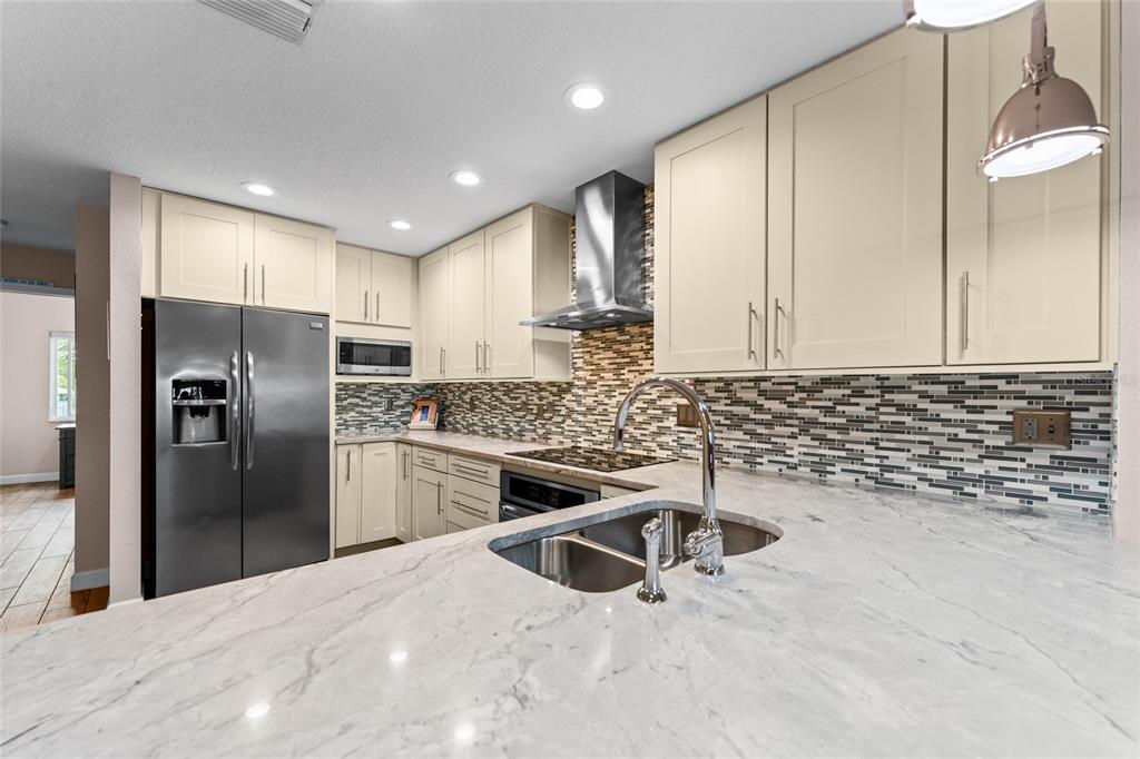 128 Marcdale Boulevard Indian Rocks Beach, FL 33785 - Photo 25 of 74 a kitchen with stainless steel appliances granite countertop a sink a stove and a refrigerator