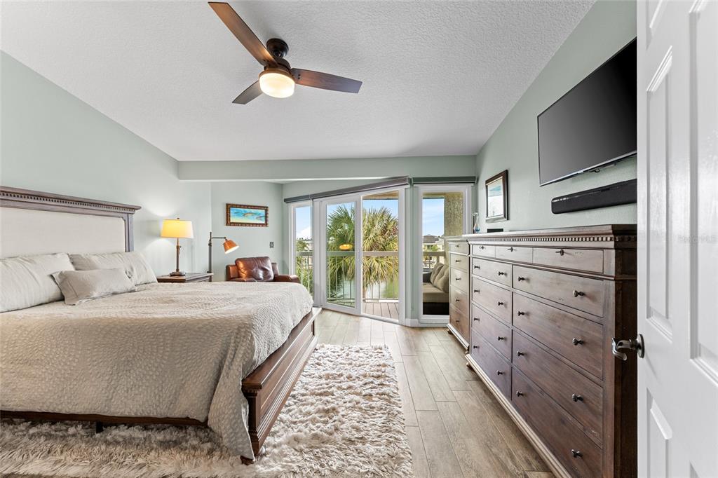 128 Marcdale Boulevard Indian Rocks Beach, FL 33785 - Photo 33 of 74 a bedroom with a large bed and a chandelier
