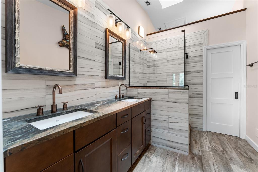 128 Marcdale Boulevard Indian Rocks Beach, FL 33785 - Photo 40 of 74 a bathroom with a double vanity sink and mirror
