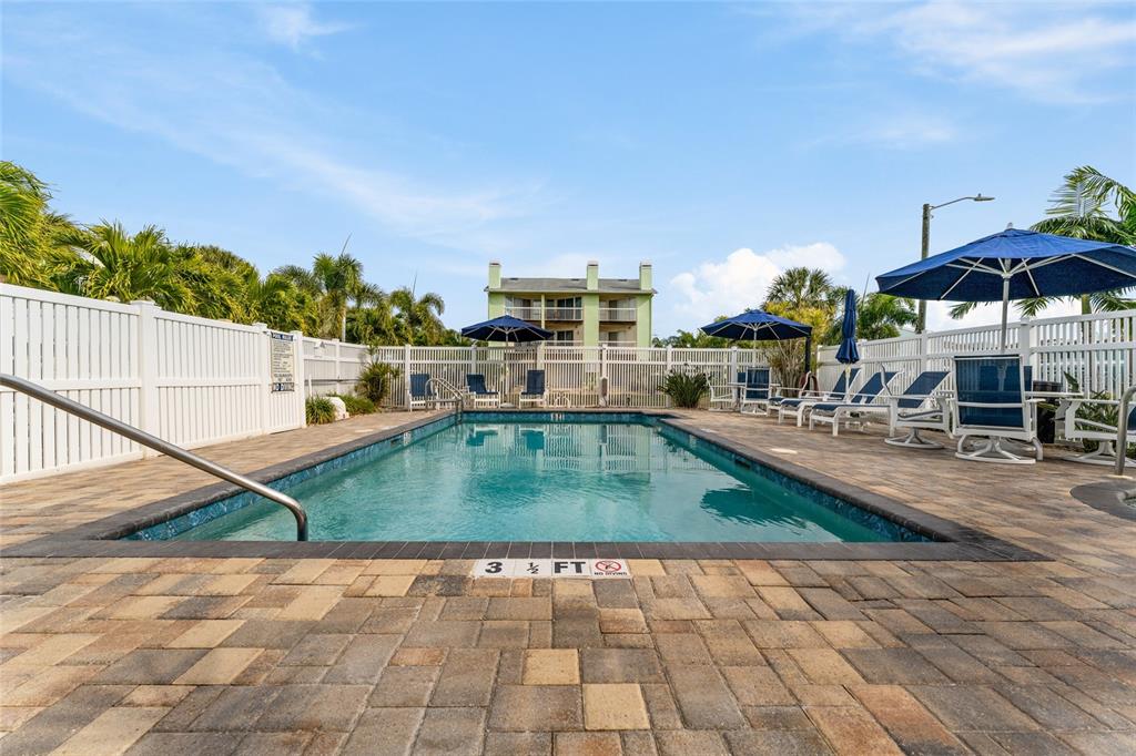 128 Marcdale Boulevard Indian Rocks Beach, FL 33785 - Photo 49 of 74 a view of a swimming pool with a lounge chairs