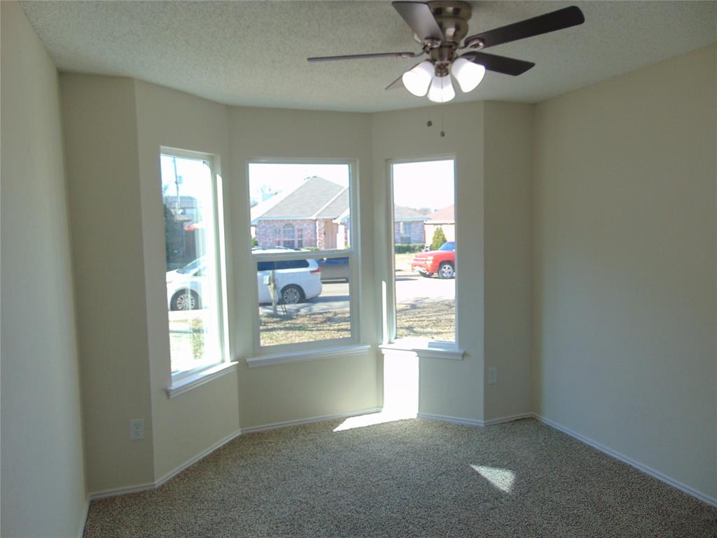 4912 Berridge Lane Dallas, TX 75227 - Photo 13 of 18 a view of an empty room with window and chandelier fan
