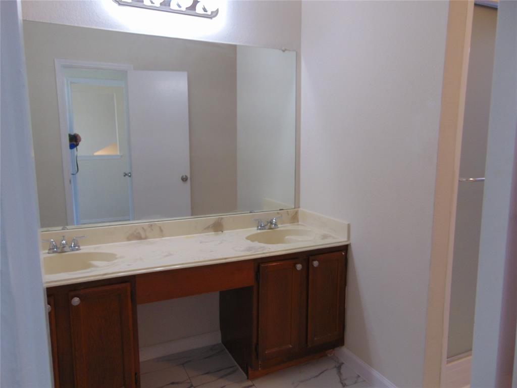 4912 Berridge Lane Dallas, TX 75227 - Photo 16 of 18 a bathroom with a granite countertop sink and a mirror