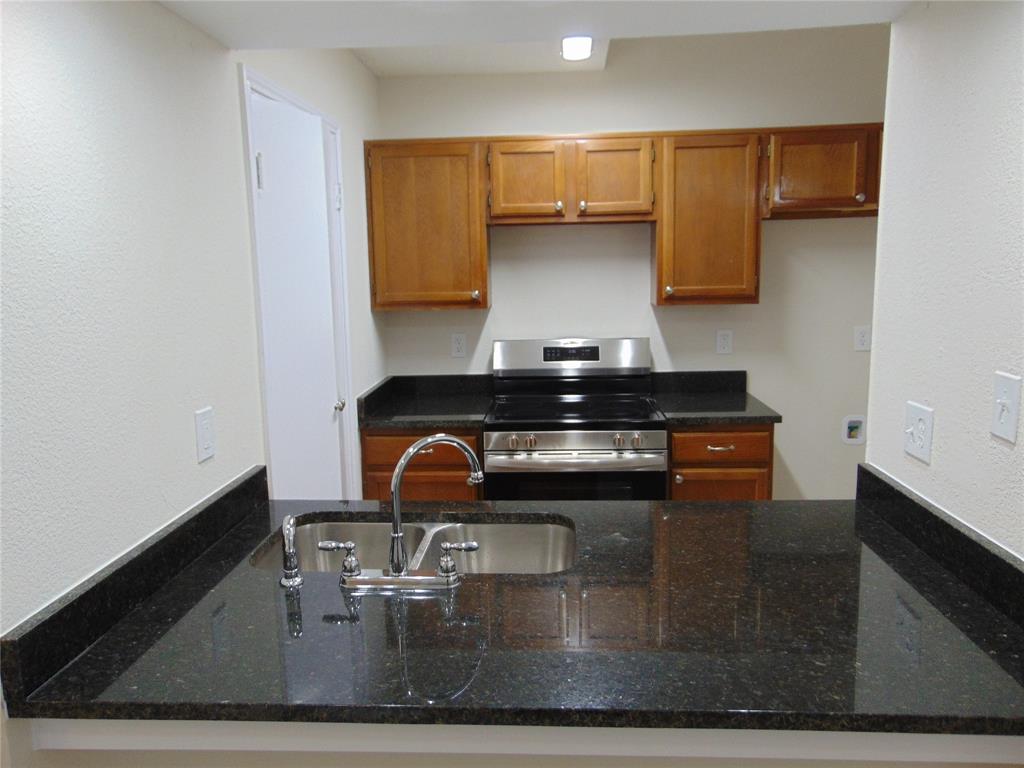 4912 Berridge Lane Dallas, TX 75227 - Photo 3 of 18 a kitchen with a sink and a stove top oven
