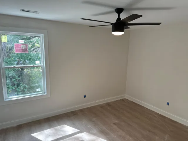 an empty room with a window and a ceiling fan