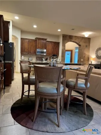 a kitchen with a dining table chairs and a refrigerator