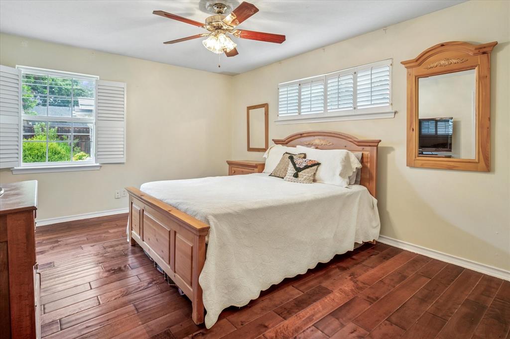 13429 Spring Grove Avenue Dallas, TX 75240 - Photo 17 of 25 a bedroom with bed and wooden floor