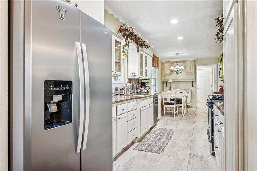 13429 Spring Grove Avenue Dallas, TX 75240 - Photo 7 of 25 a kitchen with stainless steel appliances granite countertop a refrigerator and a sink