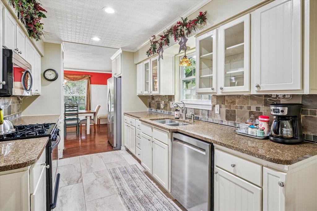 13429 Spring Grove Avenue Dallas, TX 75240 - Photo 9 of 25 a kitchen with stainless steel appliances granite countertop a stove a sink and a microwave