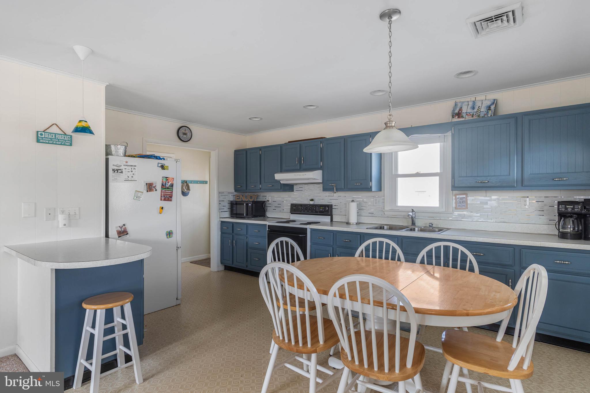 30200 Kent Road Dagsboro, DE 19939 - Photo 10 of 48 a kitchen with stainless steel appliances granite countertop a sink a stove a dining table and chairs