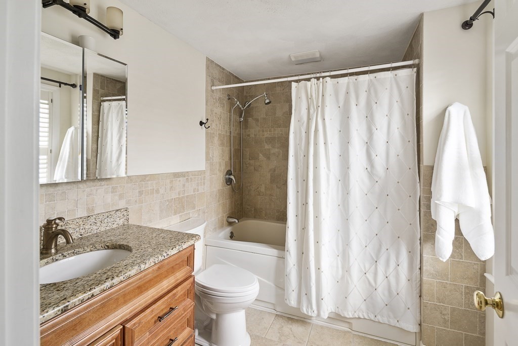 102 4th Street, Unit 2 Medford, MA 02155 - Photo 11 of 17 a bathroom with a granite countertop sink a toilet and shower