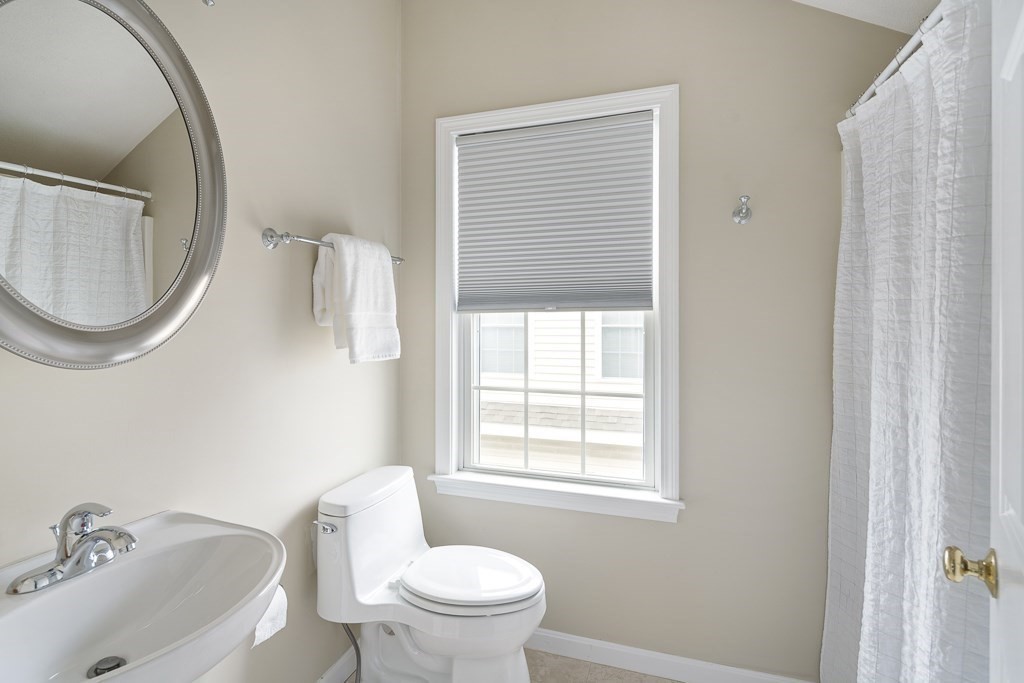 102 4th Street, Unit 2 Medford, MA 02155 - Photo 13 of 17 a white toilet sitting next to a bathroom sink