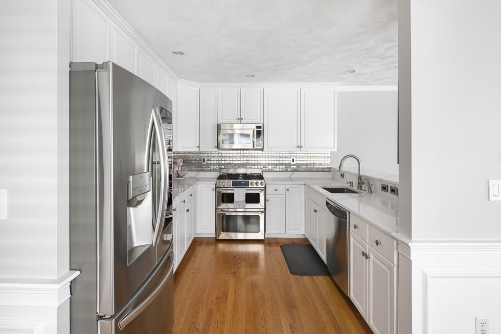 102 4th Street, Unit 2 Medford, MA 02155 - Photo 5 of 17 a kitchen with a sink a counter top space stainless steel appliances and a window