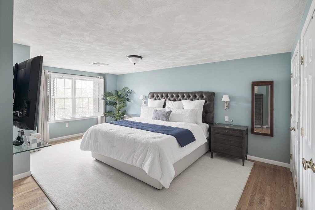 102 4th Street, Unit 2 Medford, MA 02155 - Photo 7 of 17 a bedroom with a large bed and a flat tv screen on dresser