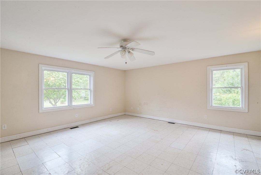 708 Buckner Road Bumpass, VA 23024 - Photo 14 of 40 an empty room with chandelier fan and windows