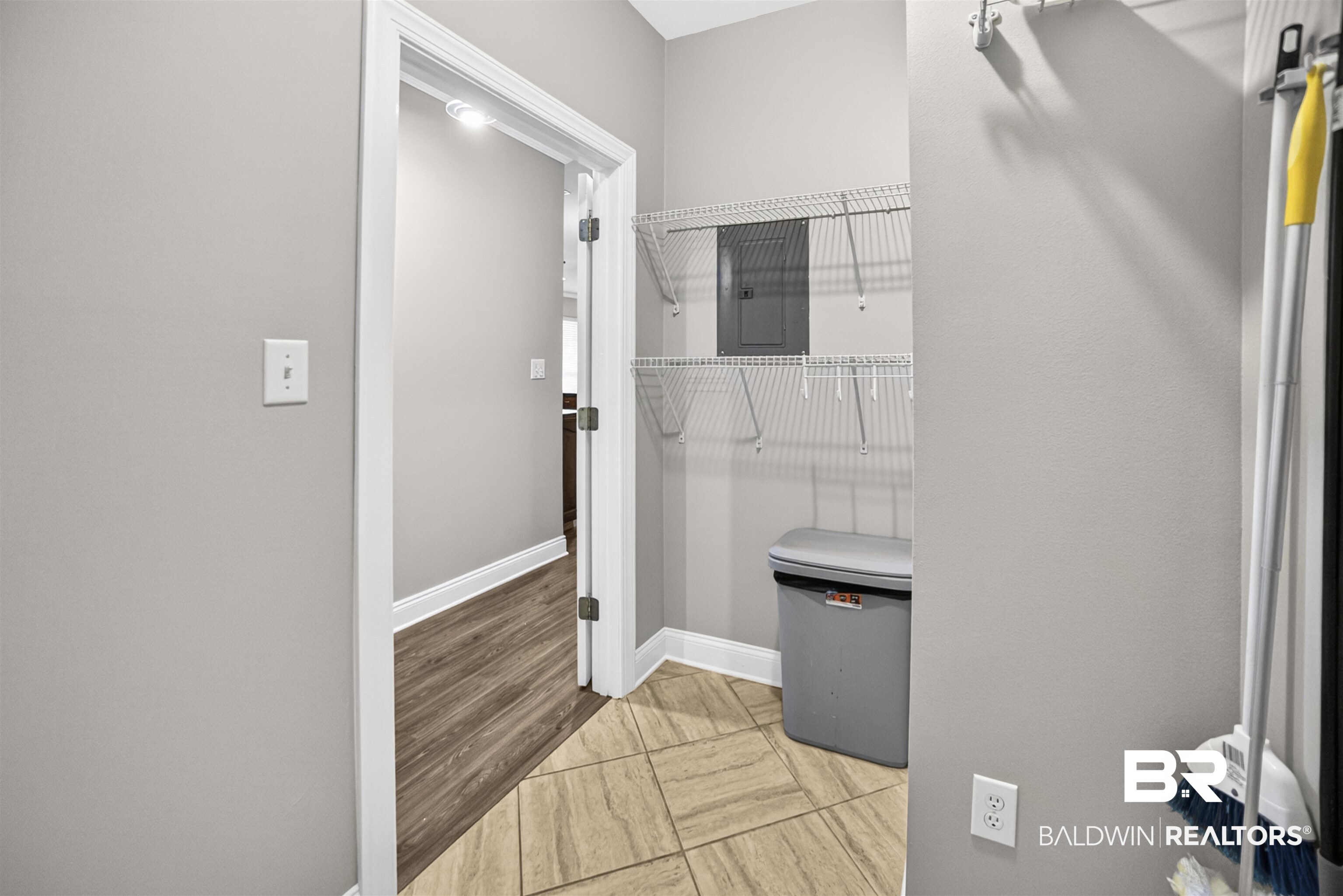 5913 Antoine Road Mobile, AL 36693 - Photo 31 of 33 Utility room featuring tile flooring, white wire shelving, a wall-mounted electrical panel, and light gray painted walls
