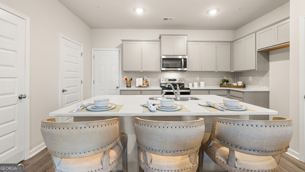 420 Reflection Drive Stockbridge, GA 30281 - Photo 15 of 58 a kitchen with stainless steel appliances granite countertop a table and chairs