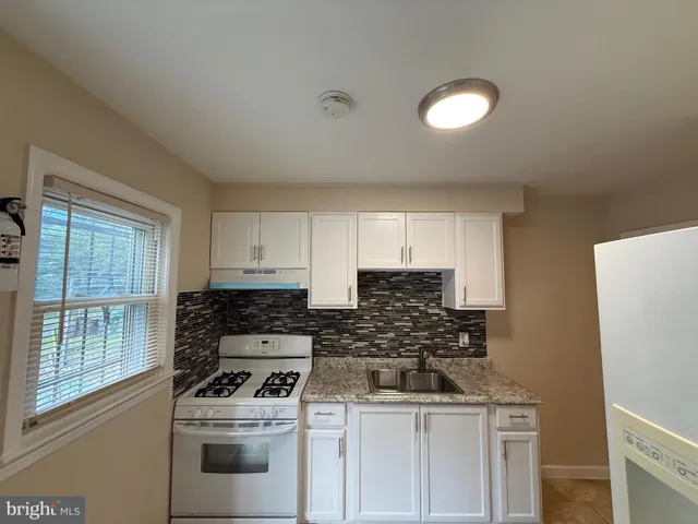 a kitchen with a stove a sink and a refrigerator